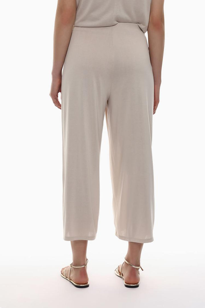 Rear view of the beige flowing culottes, showcasing their drape and clean lines.