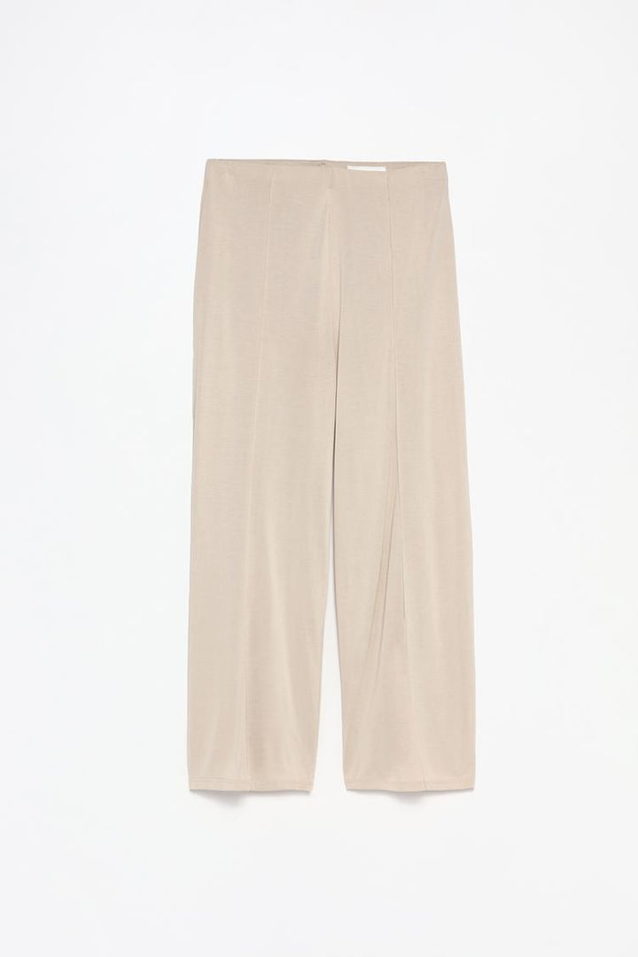 Full-body view of the beige flowing culottes, illustrating the complete outfit and length.