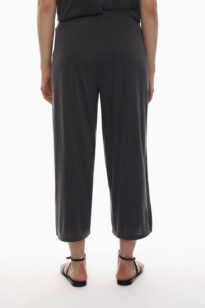 Back view of the beige-grey flowing culottes, emphasizing their sleek and polished finish.