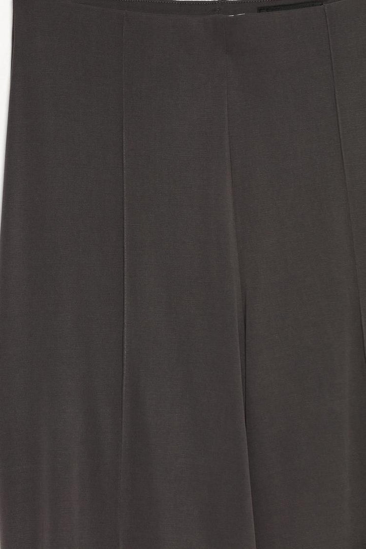 Close-up product shot of the beige-grey flowing culottes, focusing on fabric texture and details.