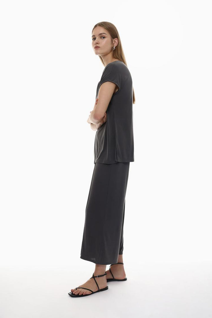 Side view of the beige-grey flowing culottes, showcasing the elegant silhouette and flowing material.