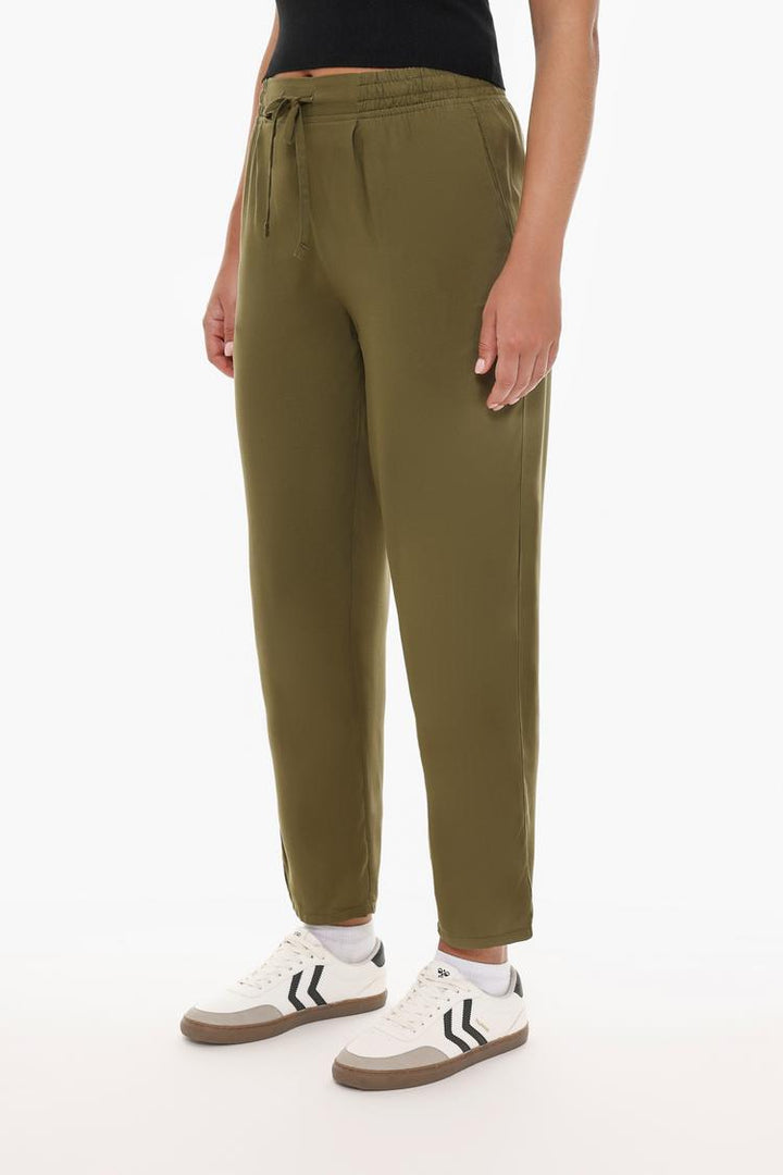 Front view of the flowing green joggers, highlighting the waistband and relaxed silhouette.