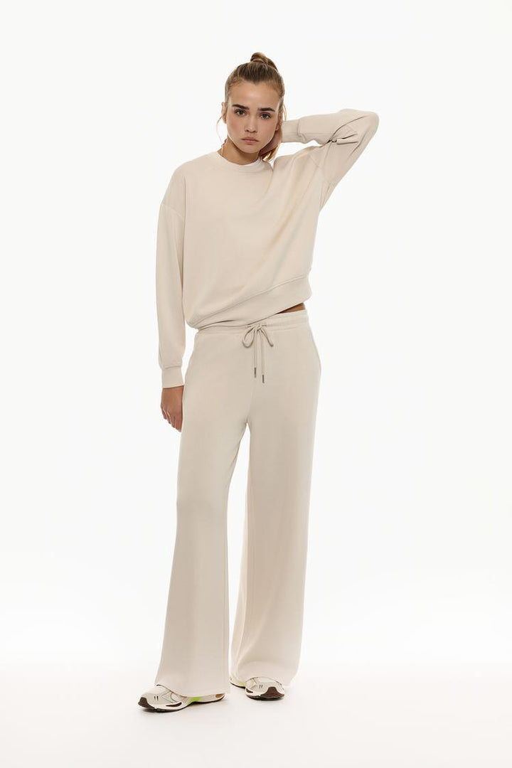 Beige flowing sports trousers with a relaxed and versatile fit.