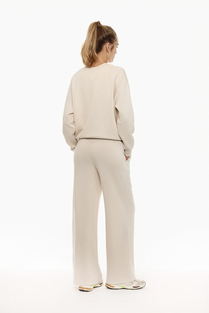 Front view of beige flowing sports trousers emphasizing the casual style.