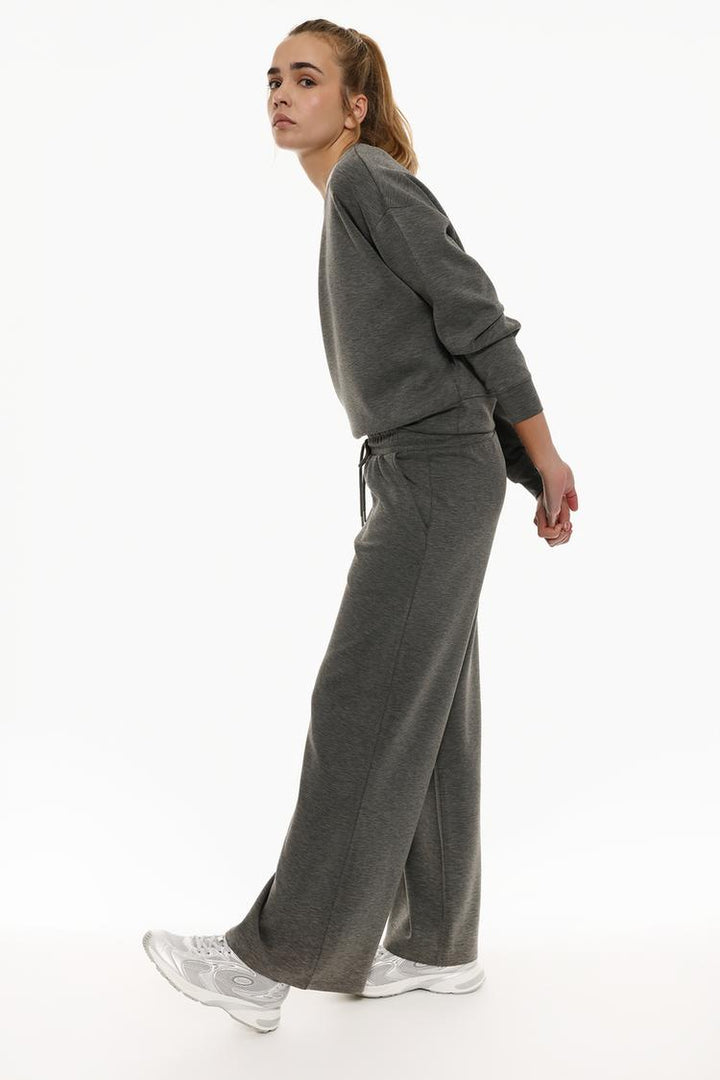 Body shot of grey flowing sports trousers highlighting the comfort and style.