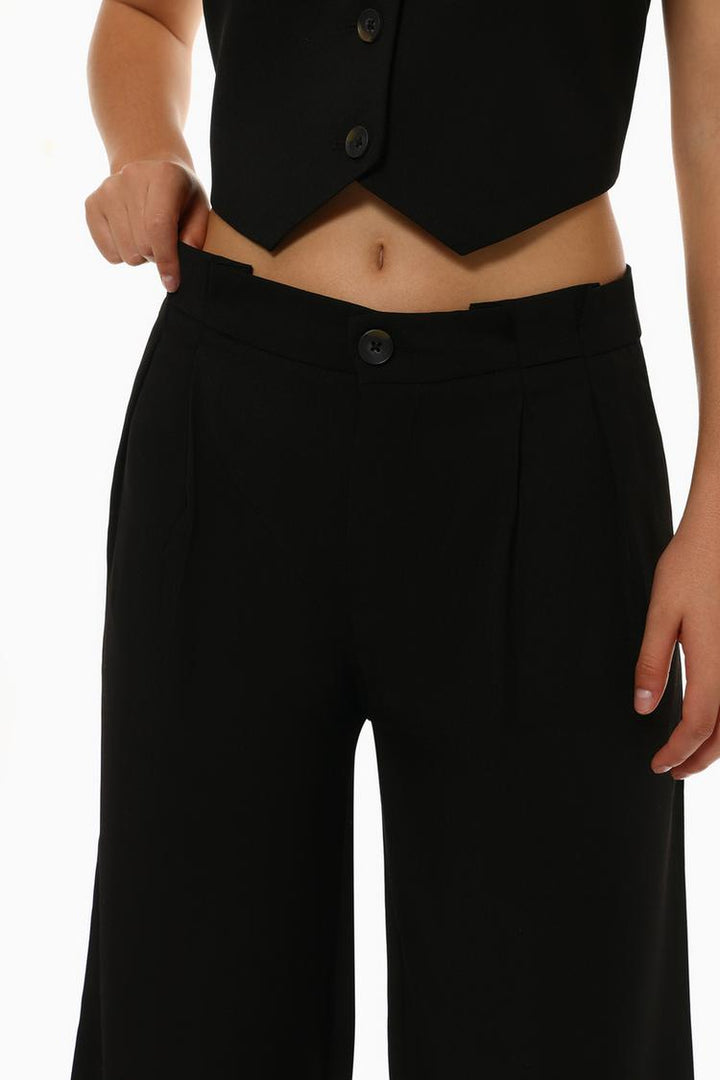 Frontal display of black formal wide-leg trousers, showcasing their structured elegance