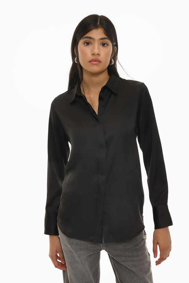 A sophisticated black long-sleeve satin shirt, designed with a sleek button-up front and a luxurious glossy finish. The smooth satin fabric provides a polished look, perfect for formal or evening wear, while the classic silhouette adds timeless elegance.