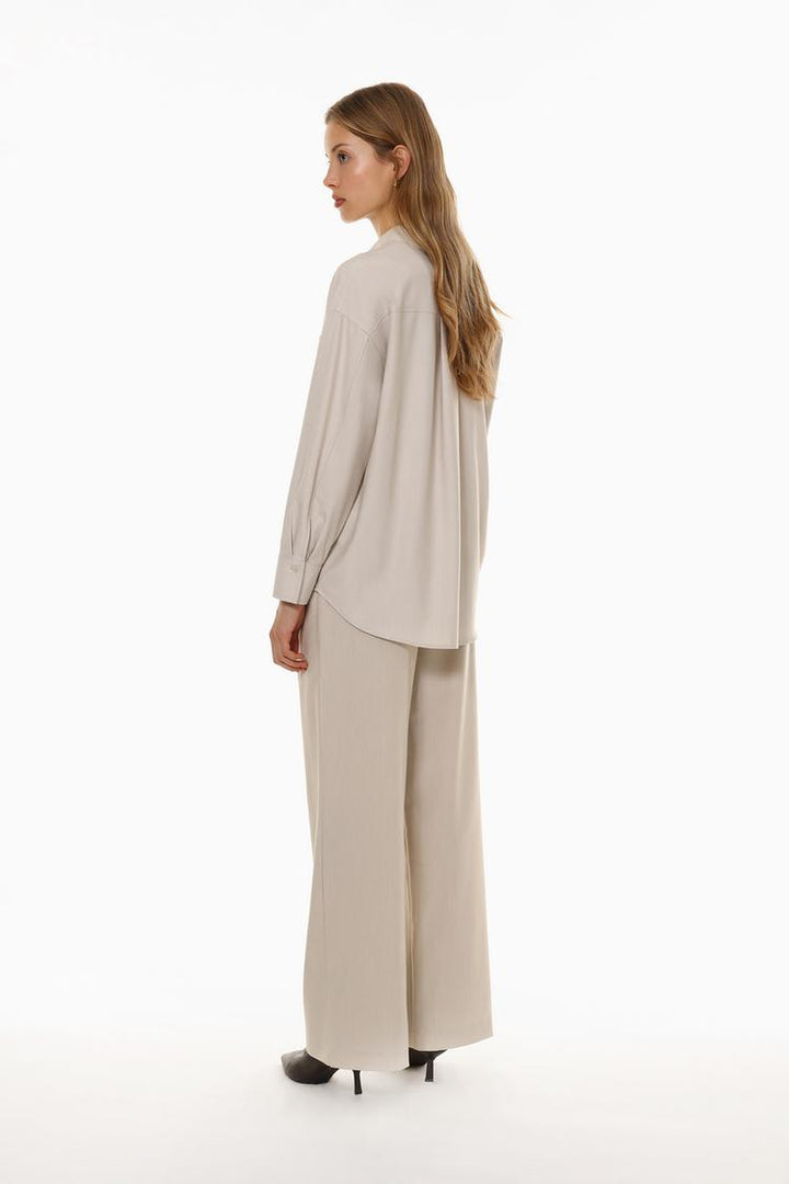 Back view of beige loose-fitting wide-leg trousers, adding an elegant touch to your outfit