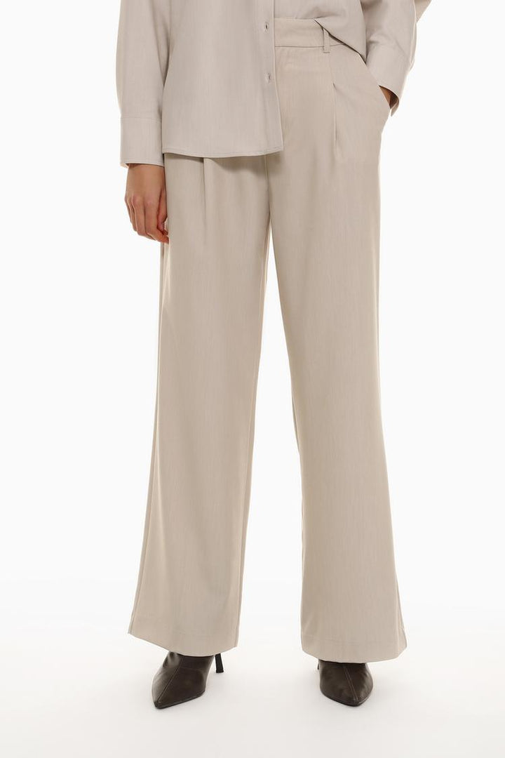 Front view of beige loose-fitting wide-leg trousers, perfect for a laid-back yet stylish look