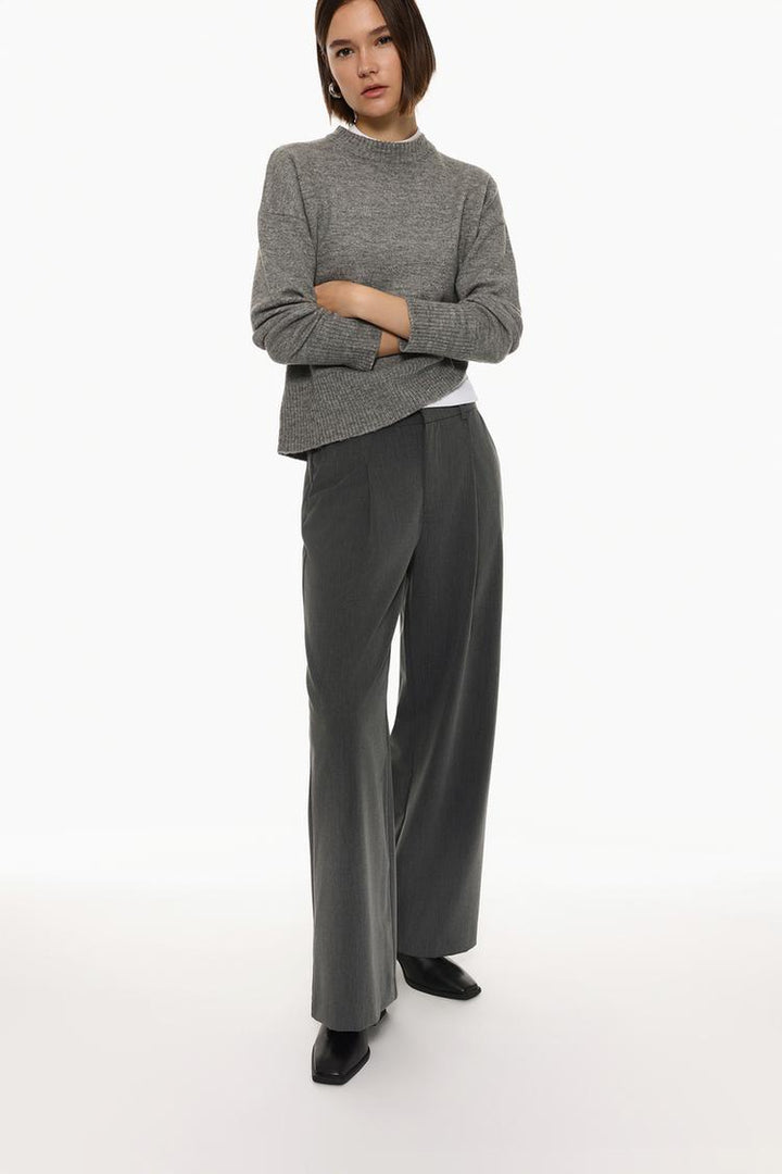 Full-body shot of grey loose-fitting wide-leg trousers, highlighting the relaxed fit and modern silhouette