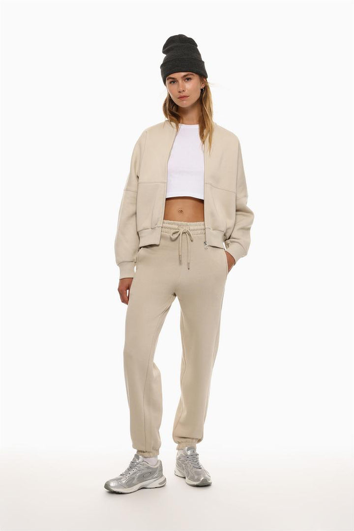 Image of beige oversized tracksuit trousers, showing their relaxed fit and comfortable design.