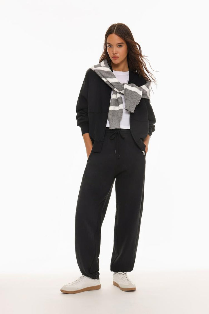 Image of black oversized tracksuit trousers, showcasing the relaxed and roomy design.