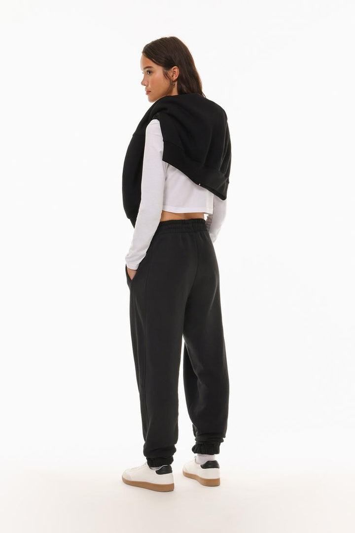 Back view of the black oversized tracksuit trousers, showing the fit and design of the waistband.