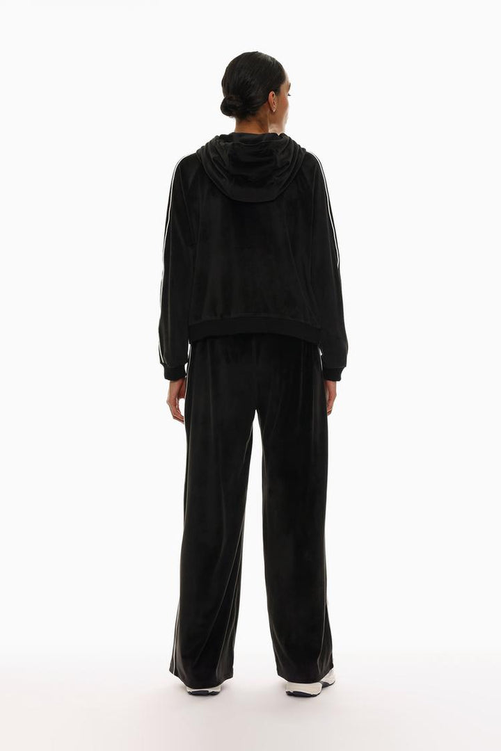 Back view of black oversized velvet trousers showing the fit and design.
