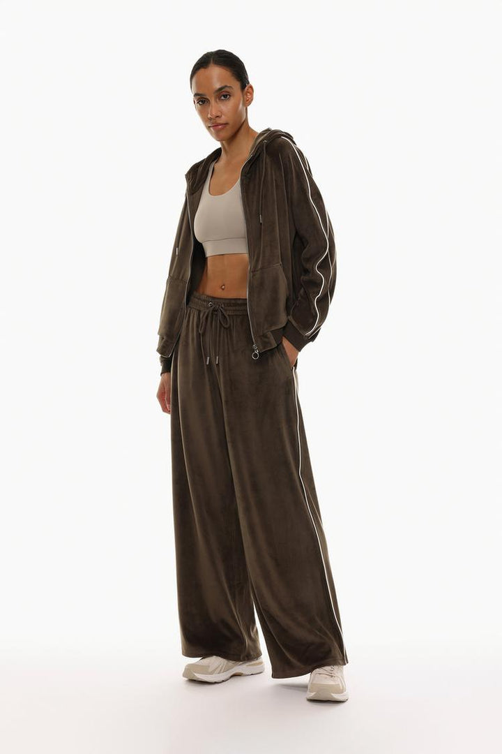 Brown oversized velvet trousers back view showcasing the fit and design.
