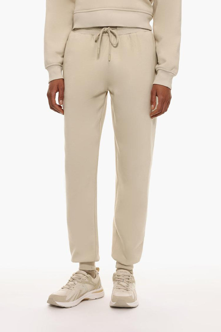 Front view of beige plush joggers highlighting the waist and leg fit.