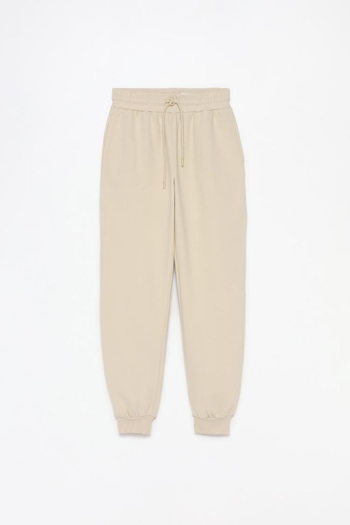 Full product view of beige plush joggers displaying the complete design.