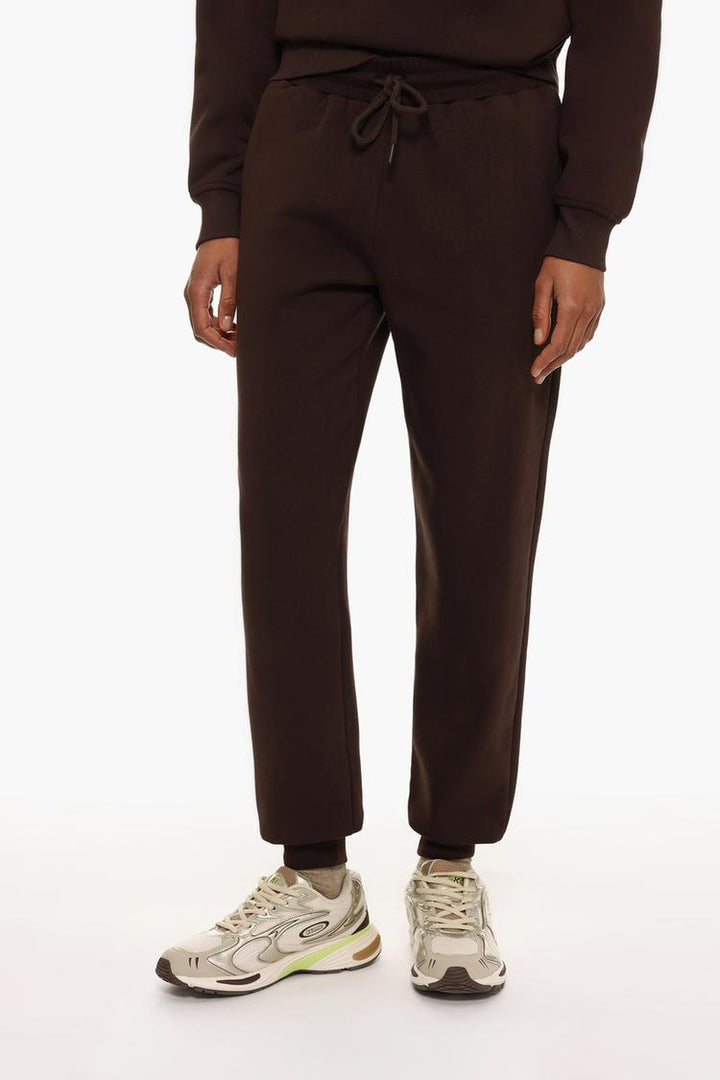 Front view of brown plush joggers highlighting the waist and leg fit.