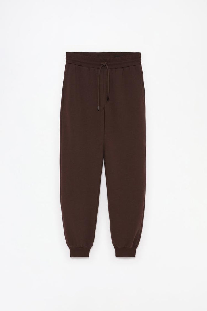 Full product view of brown plush joggers displaying the complete design.