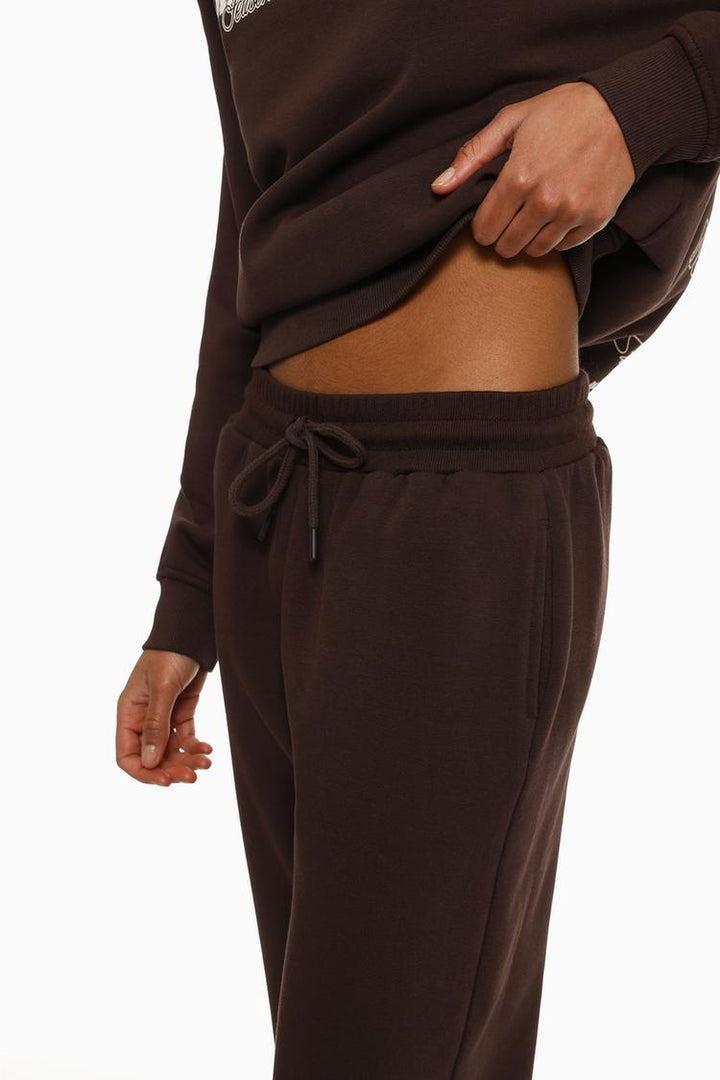 Side view of brown plush joggers showing the silhouette and overall fit.