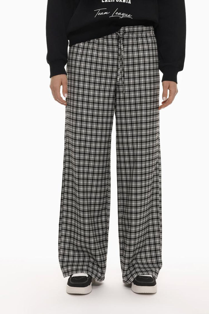 Front view of white printed jogging trousers, highlighting the eye-catching pattern and elastic waistband.