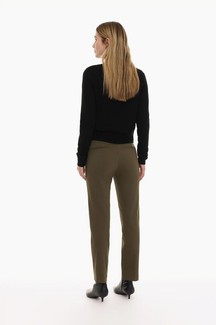 Full-body display of brown slim fit trousers with a belt, styled for a sophisticated look