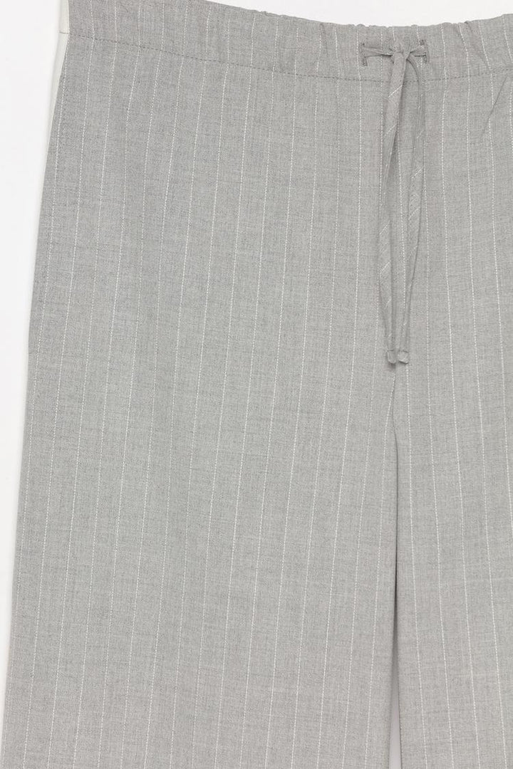 Detailed product display of grey smart trousers with a waistband, crafted for lasting quality