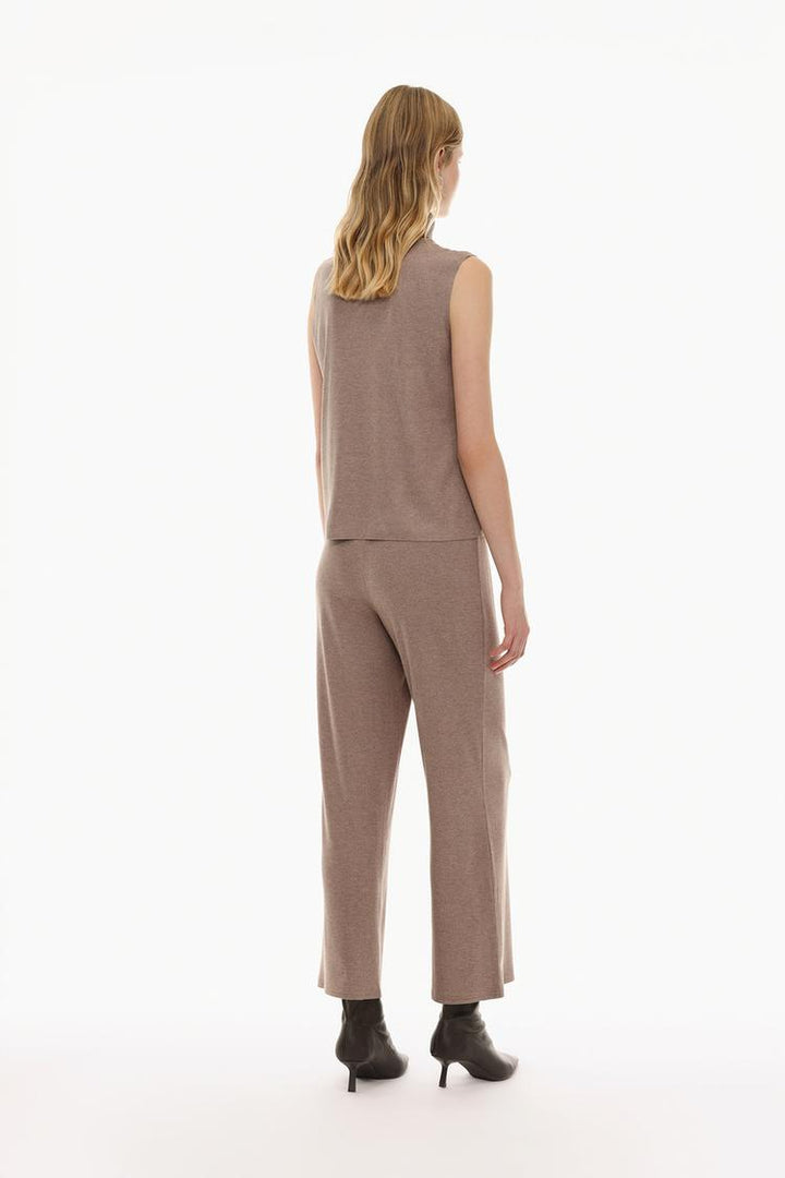 View of the brown soft-touch trousers from the back, highlighting the clean stitching and overall design.