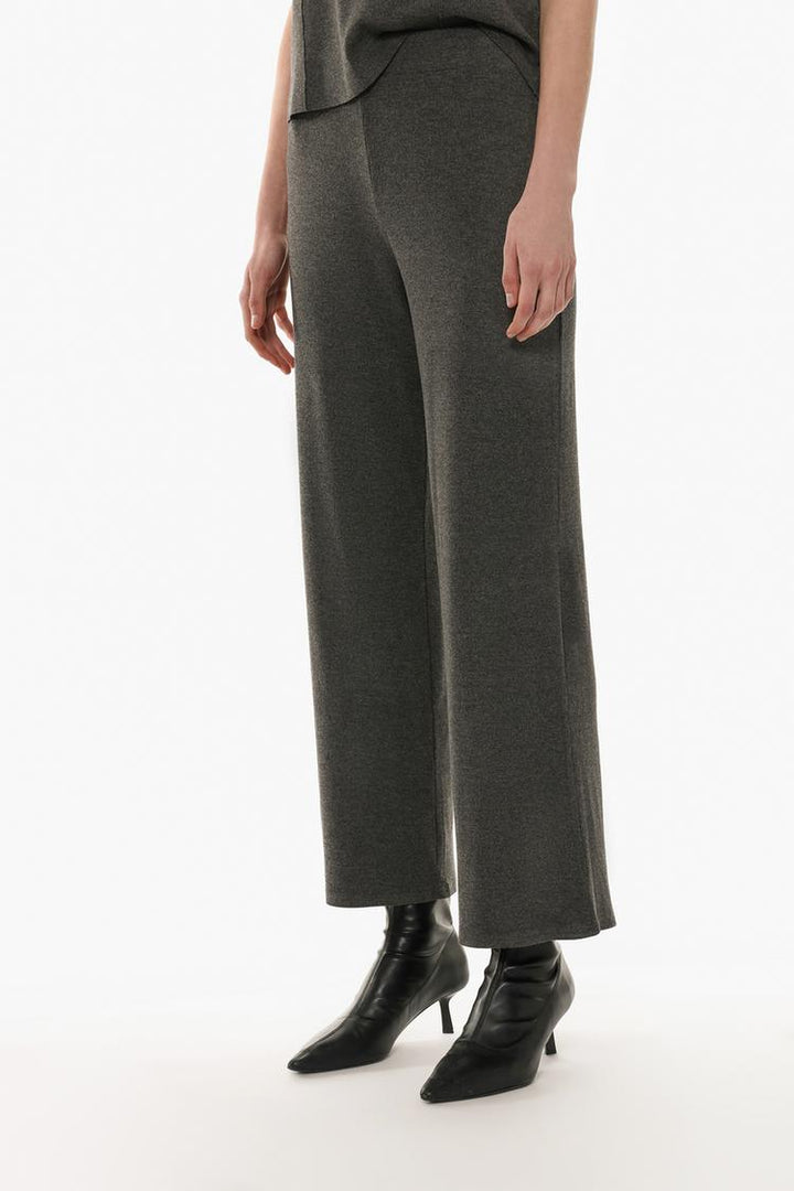 Front-facing image of the grey trousers, highlighting their sleek design and polished appearance.