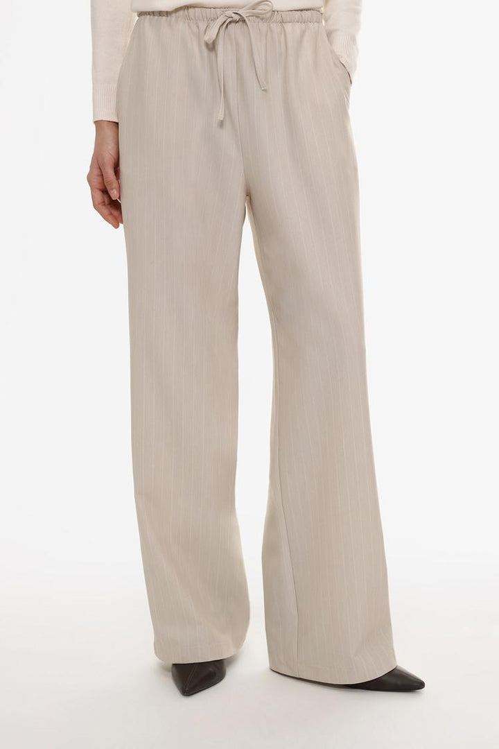 Front view of beige straight-fit trousers, tailored for a chic and polished look
