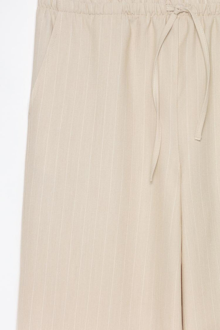 Detailed product display of beige straight-fit trousers, perfect for casual and office wear