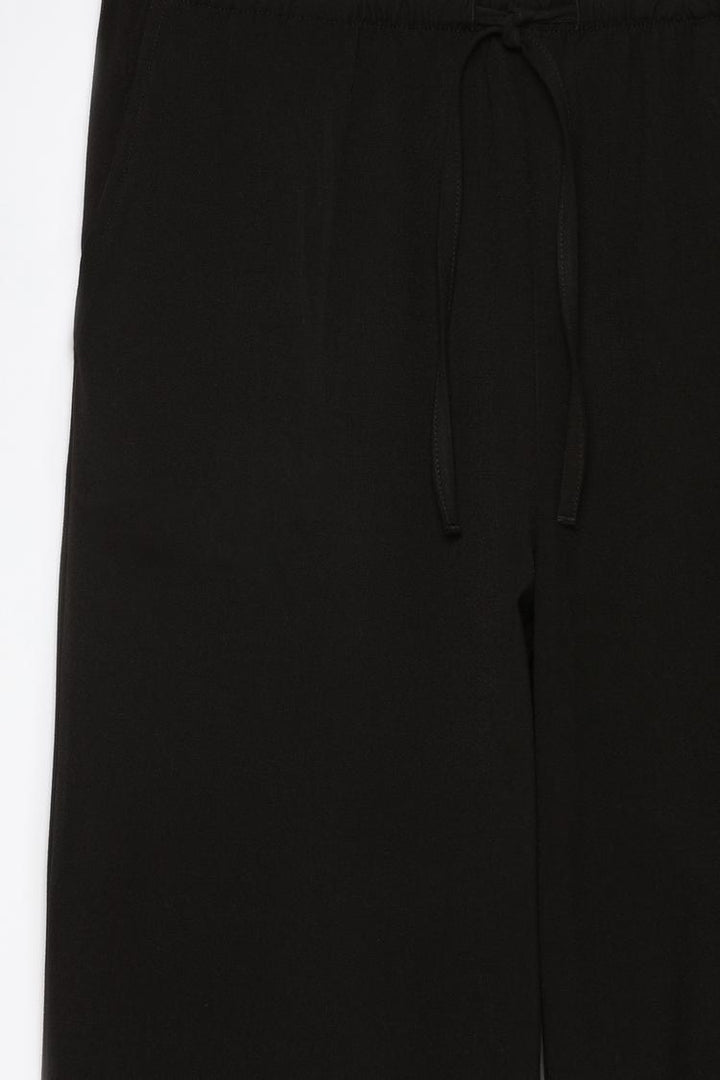 Detailed product view of black straight-fit trousers, designed for comfort and elegance