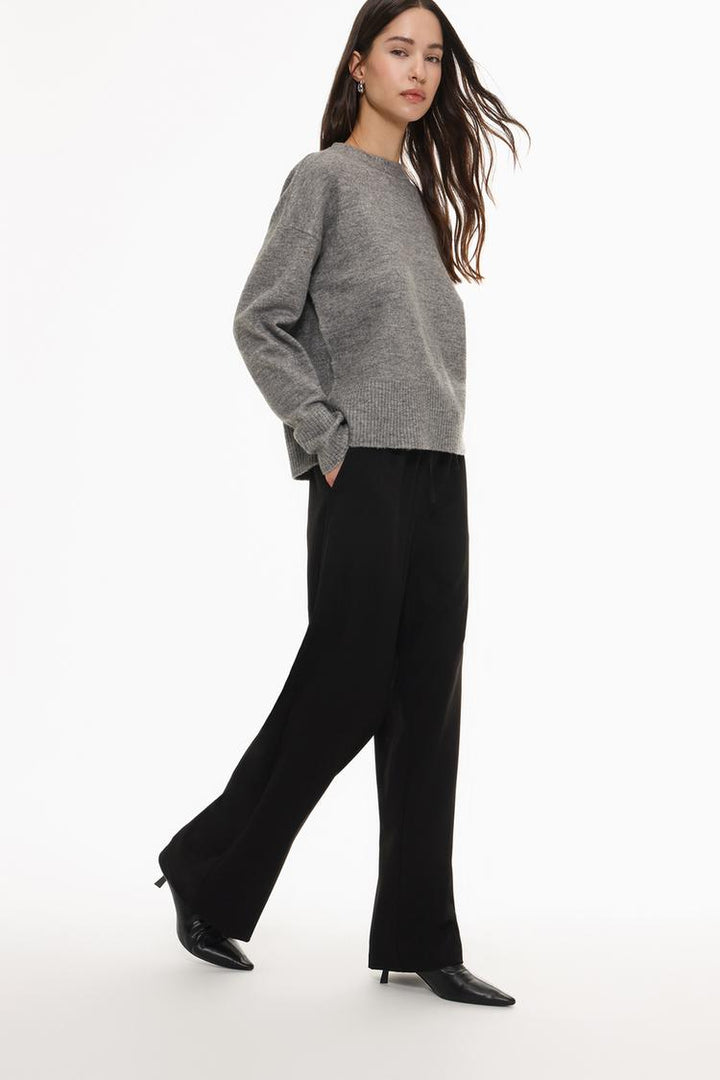 Side view of black straight-fit trousers, emphasizing their tailored fit and clean lines