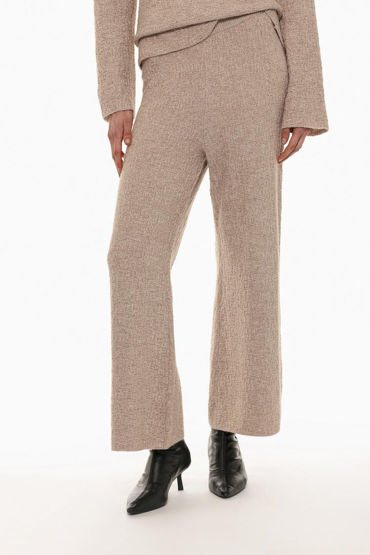 Front view of the textured knit trousers in beige, showcasing the waistband and knit detailing.