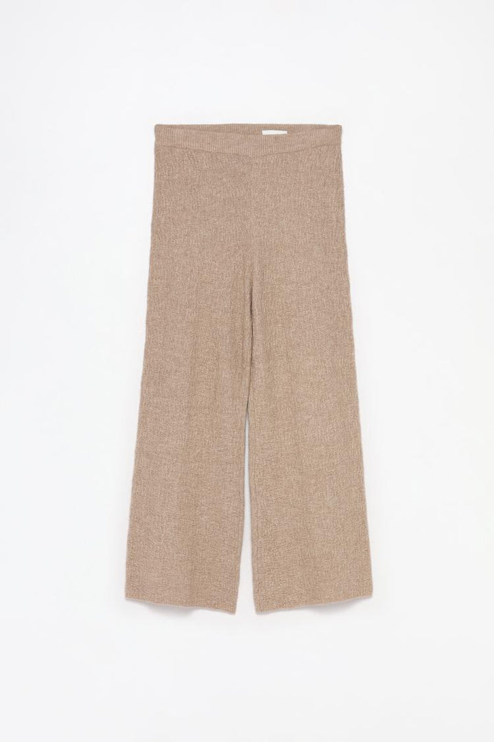 Comprehensive product shot of the beige textured knit trousers, highlighting the material and style.