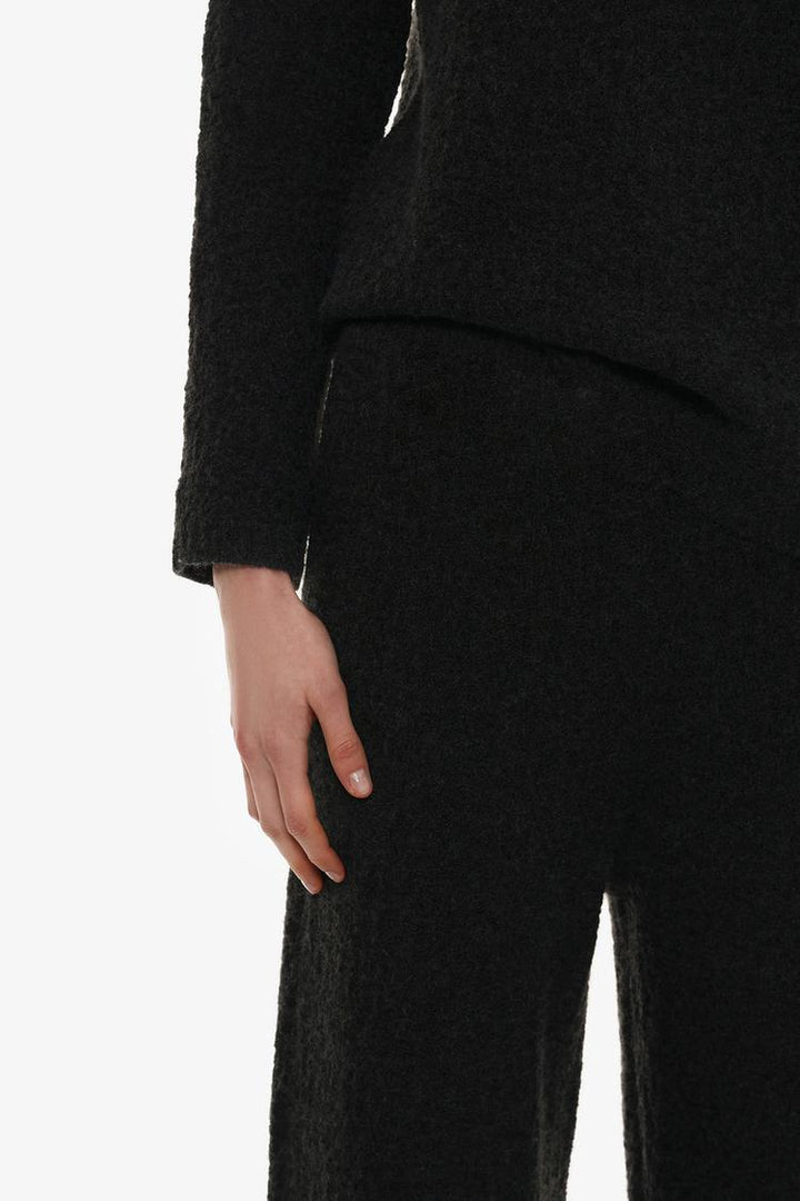 Stylish ensemble featuring the black textured knit trousers, perfect for various occasions.