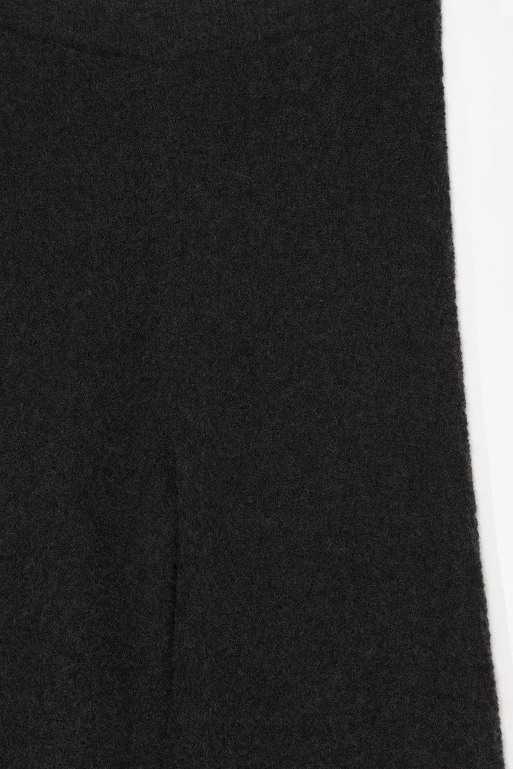 Close-up of the black textured knit trousers, showcasing intricate knit detailing and fabric quality.