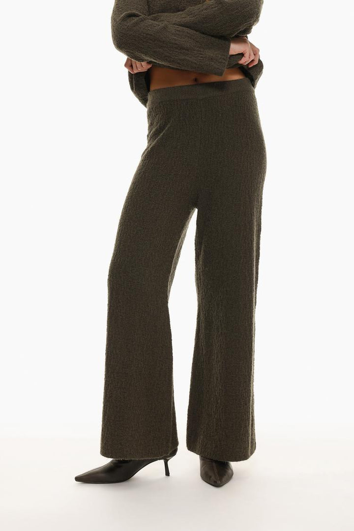 Front view of the green textured knit trousers, focusing on the knit pattern and waist design.