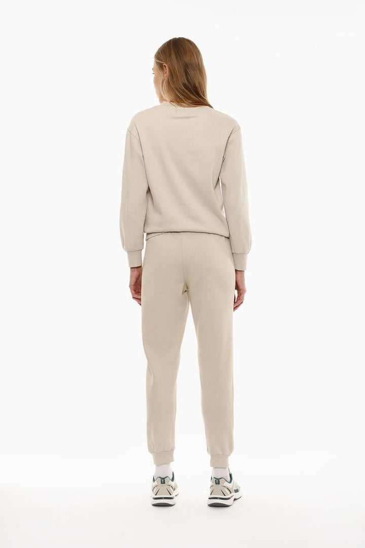 Back view of beige tracksuit bottoms showing the design and fit.