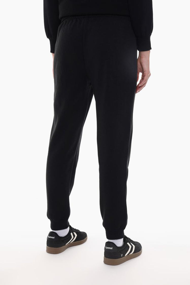 Back view of black tracksuit bottoms showing the fit and design.