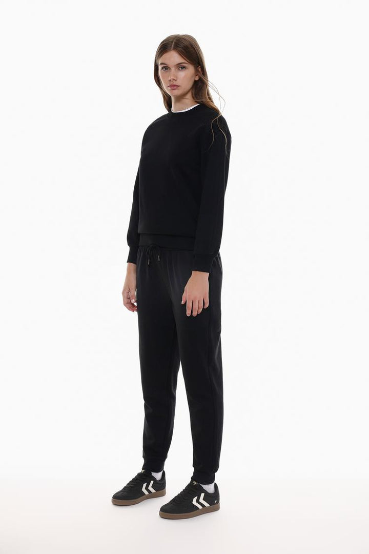 Front view of black tracksuit bottoms showing the waist and leg fit.