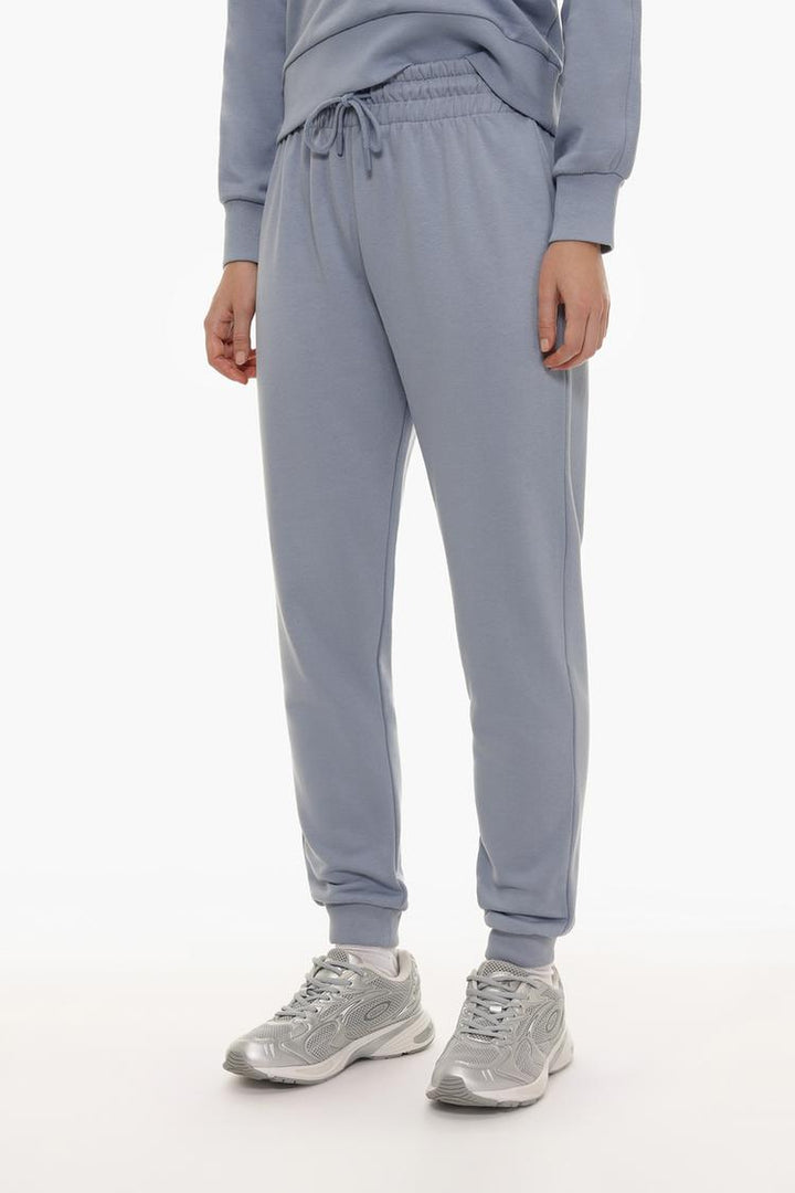 Front view of blue tracksuit bottoms showing the waist and legs.