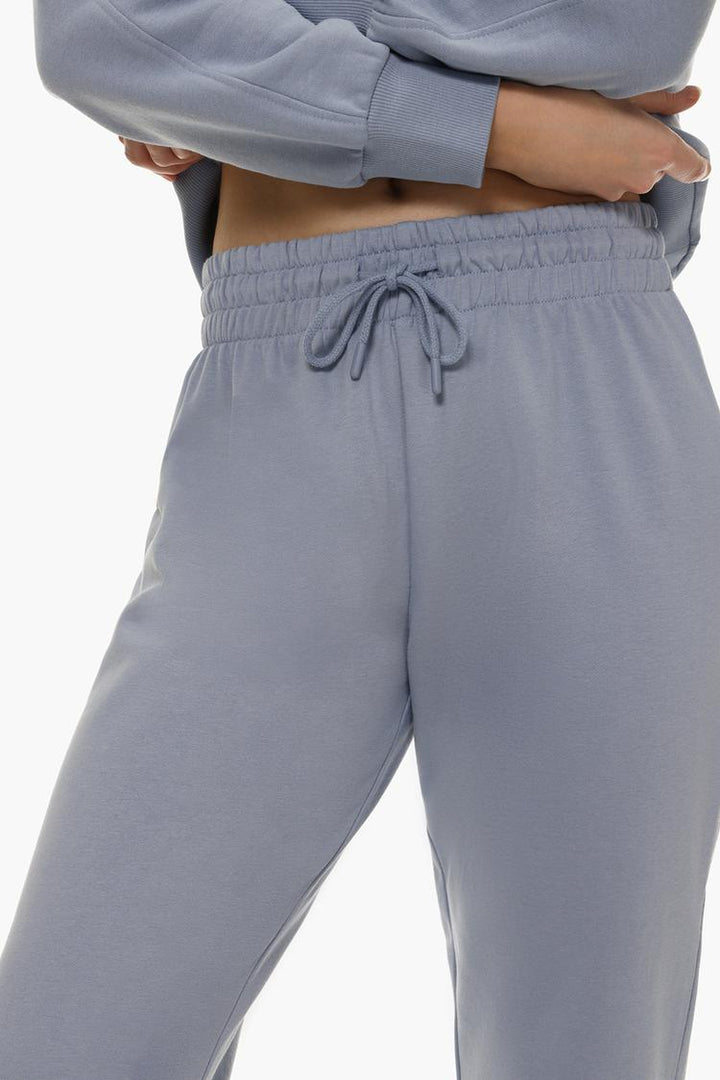 Detailed shot of blue tracksuit bottoms highlighting fabric and style.