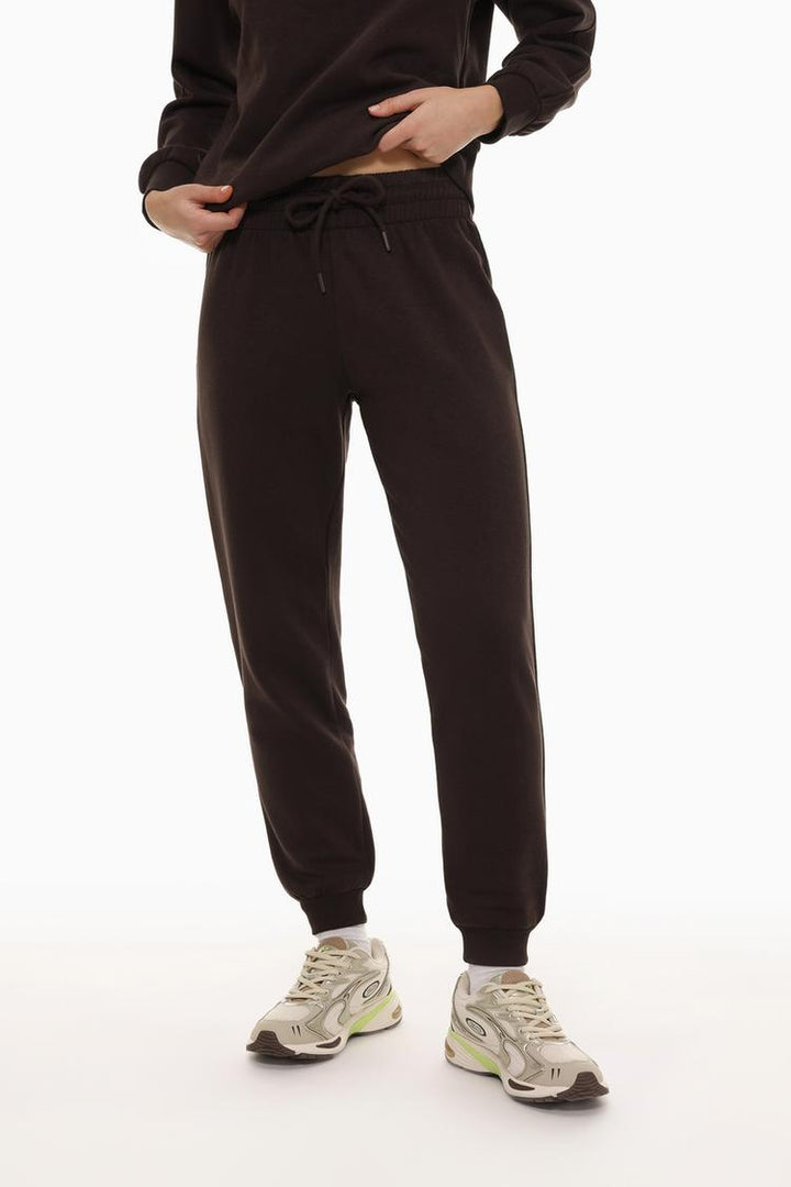 Tracksuit bottoms brown front view showing the relaxed fit, drawstring waist, and sleek design for a casual and comfortable look.