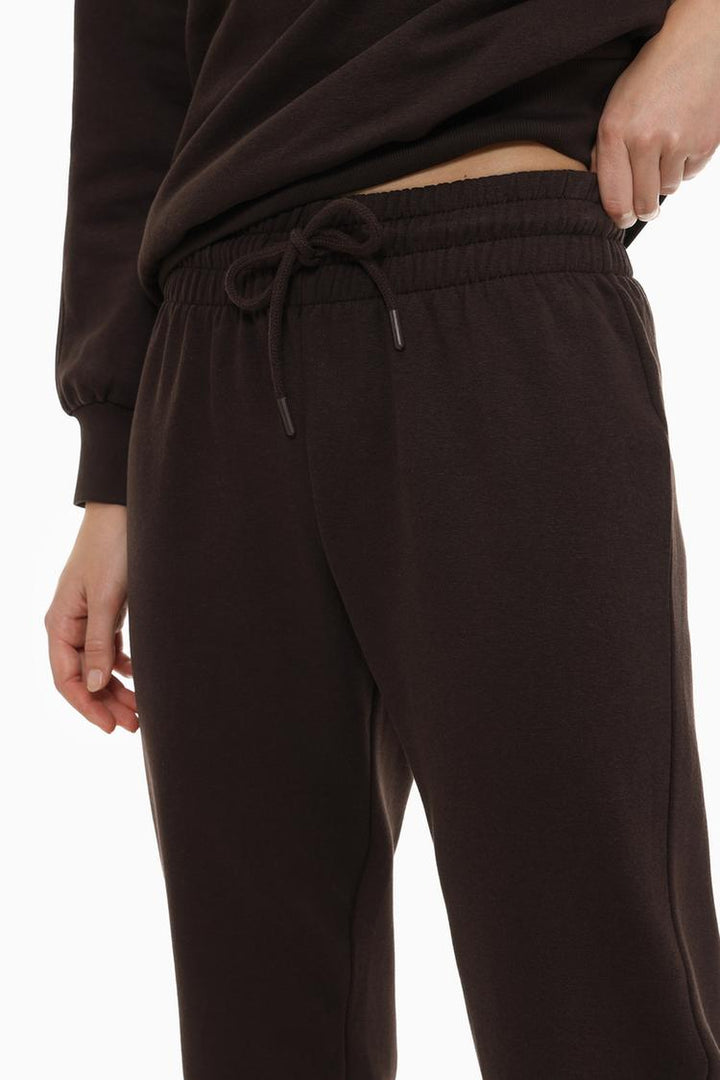 Tracksuit bottoms brown close-up zoomed-in view highlighting the fabric texture, stitching details, and drawstring waist for a comfortable and stylish fit.