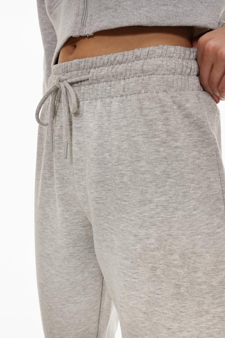 Zoomed-in view of grey tracksuit bottoms to highlight fabric texture and details.