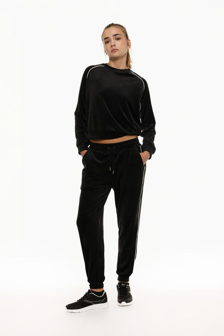 Black velvet joggers with a soft, luxurious texture and relaxed fit.