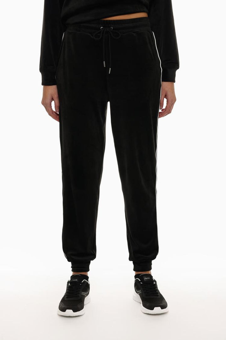 Front view of black velvet joggers highlighting the waist and leg fit.