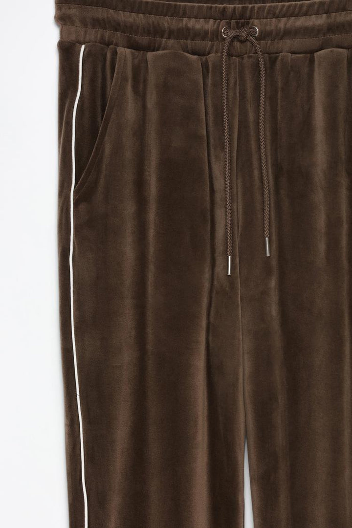 Product view of brown velvet joggers showcasing the fabric and details.