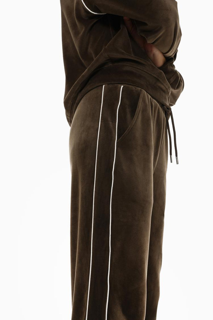 Side view of brown velvet joggers showing the overall silhouette and design.